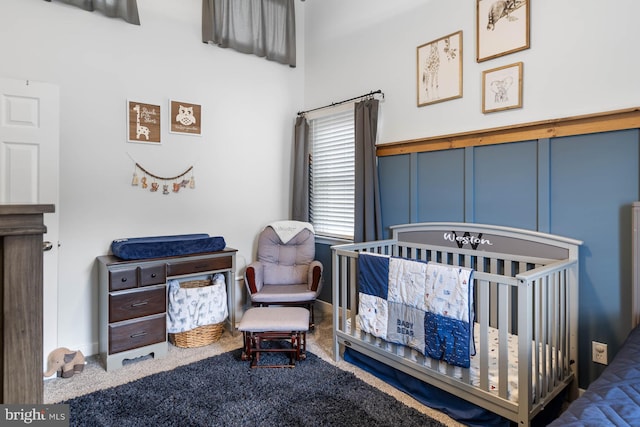 bedroom with a crib and carpet floors