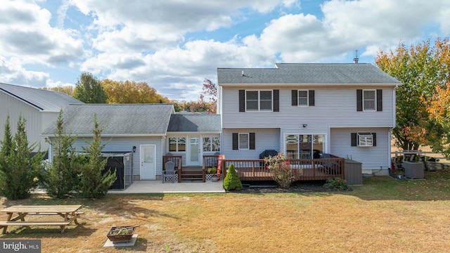 rear view of house with central air condition unit, a yard, and a wooden deck