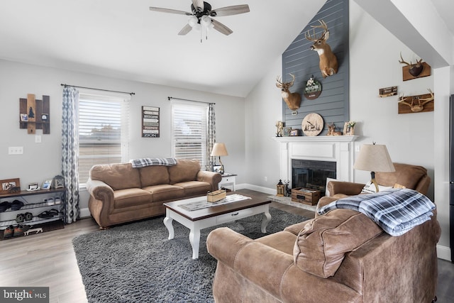 living room with high vaulted ceiling, ceiling fan, and light hardwood / wood-style flooring