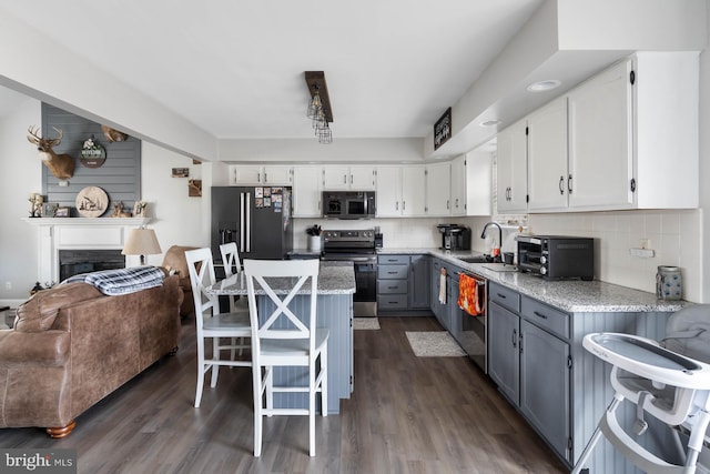 kitchen with stainless steel appliances, dark hardwood / wood-style floors, backsplash, and gray cabinetry