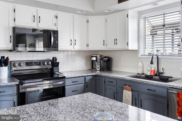 kitchen featuring stainless steel appliances, white cabinetry, sink, backsplash, and gray cabinets