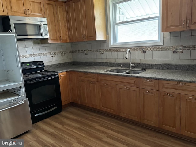 kitchen featuring stainless steel appliances, tasteful backsplash, dark hardwood / wood-style floors, and sink