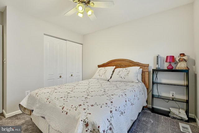 bedroom with ceiling fan, a closet, and dark colored carpet