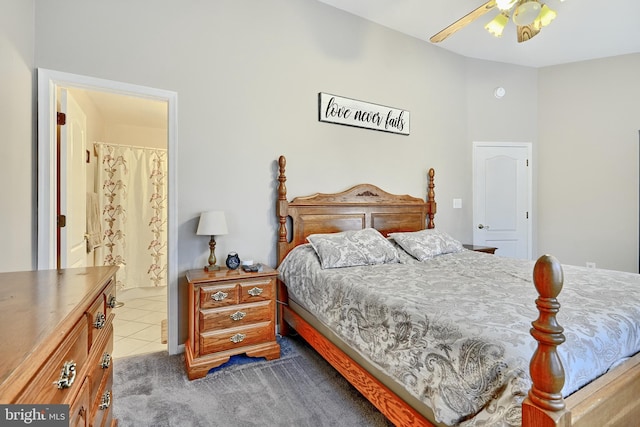 bedroom with dark colored carpet, ensuite bathroom, and ceiling fan