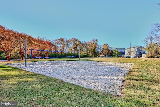 view of property's community with volleyball court and a lawn