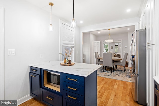 kitchen featuring light hardwood / wood-style floors, appliances with stainless steel finishes, and blue cabinets