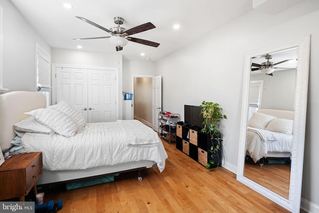 bedroom featuring hardwood / wood-style floors, ceiling fan, and a closet