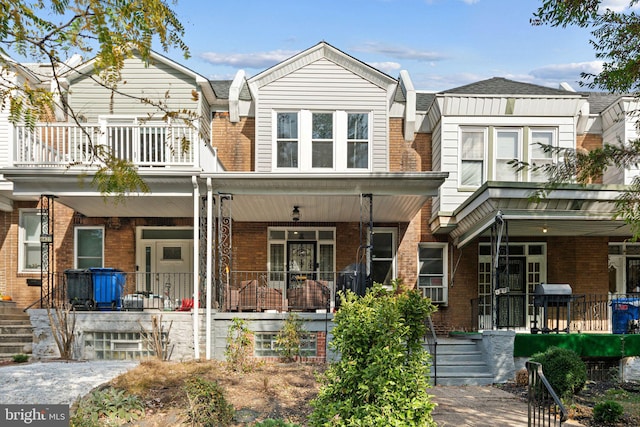 view of property with covered porch and a balcony