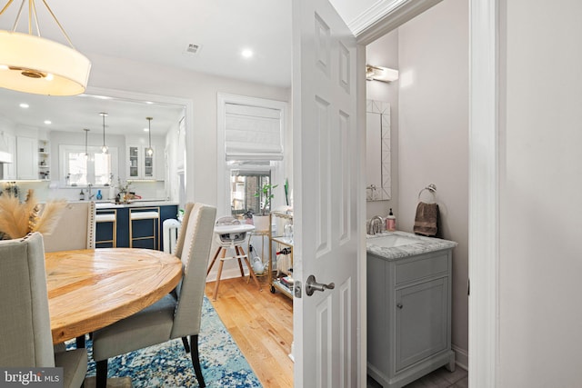 dining area with plenty of natural light, sink, and light hardwood / wood-style flooring