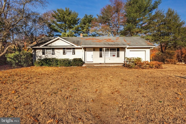 ranch-style house with a garage, a front yard, and covered porch