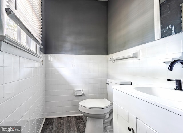 bathroom featuring tile walls, hardwood / wood-style floors, vanity, and toilet