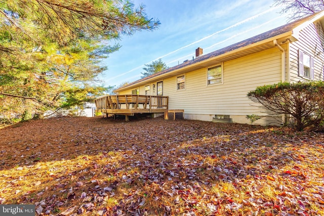 rear view of house featuring a wooden deck