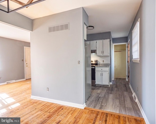 kitchen with hardwood / wood-style floors and stainless steel electric stove