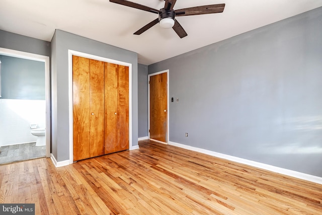 unfurnished bedroom with connected bathroom, a closet, light wood-type flooring, and ceiling fan