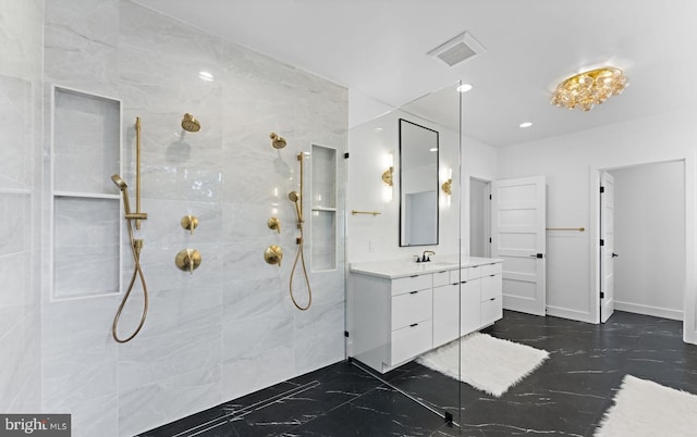 bathroom with tiled shower and vanity