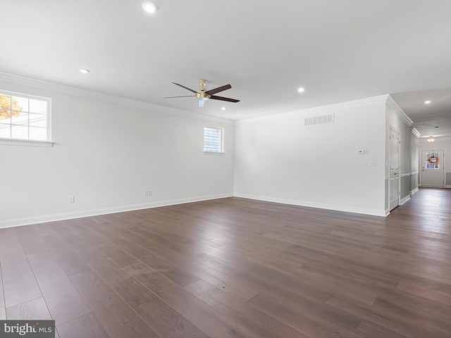 empty room featuring dark hardwood / wood-style flooring, a healthy amount of sunlight, crown molding, and ceiling fan