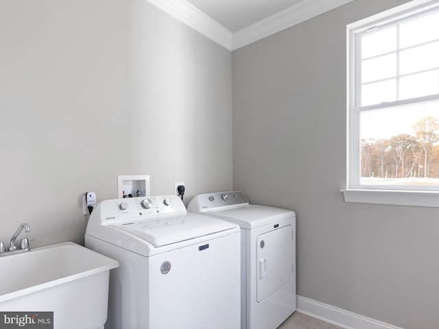 washroom featuring crown molding, sink, and washer and clothes dryer