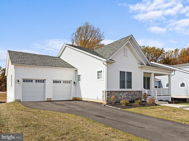 view of side of home featuring covered porch, a garage, and a yard