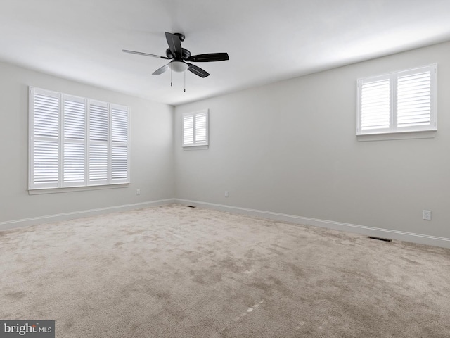 carpeted spare room with ceiling fan