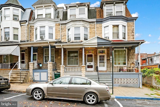 view of property featuring cooling unit and a porch