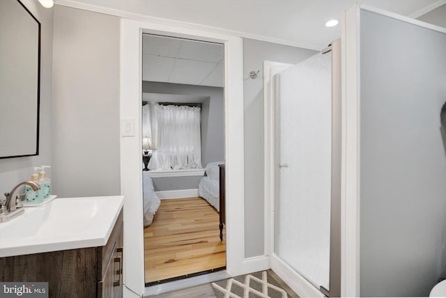 bathroom with vanity, hardwood / wood-style floors, and ornamental molding