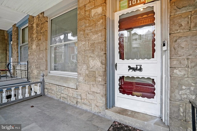 view of exterior entry featuring covered porch