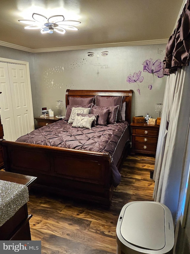 bedroom with dark wood-type flooring, a closet, and ornamental molding