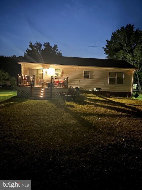 back house at dusk with a lawn