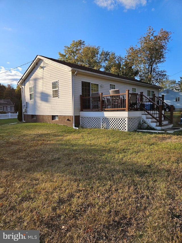 back of house featuring a deck and a lawn