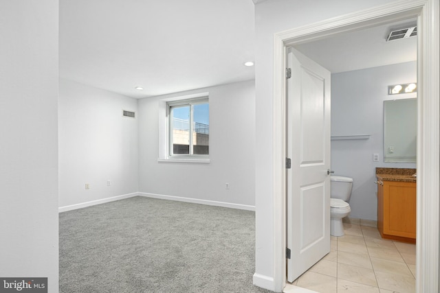 interior space with tile patterned floors, vanity, and toilet