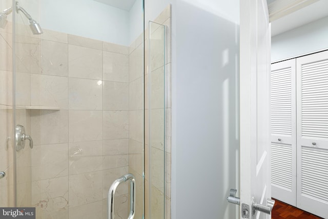 bathroom with hardwood / wood-style floors and a shower with door