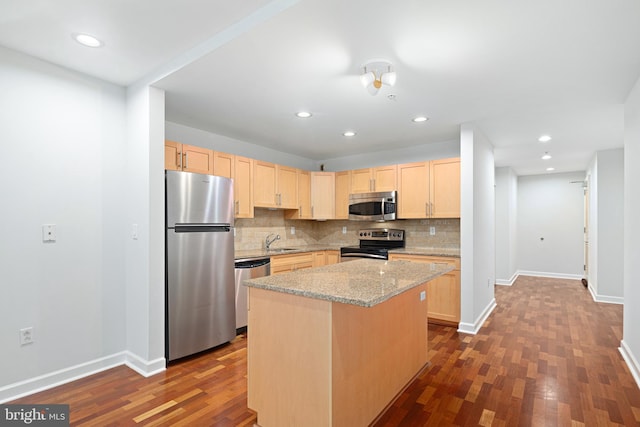 kitchen with light stone countertops, a center island, sink, dark wood-type flooring, and stainless steel appliances