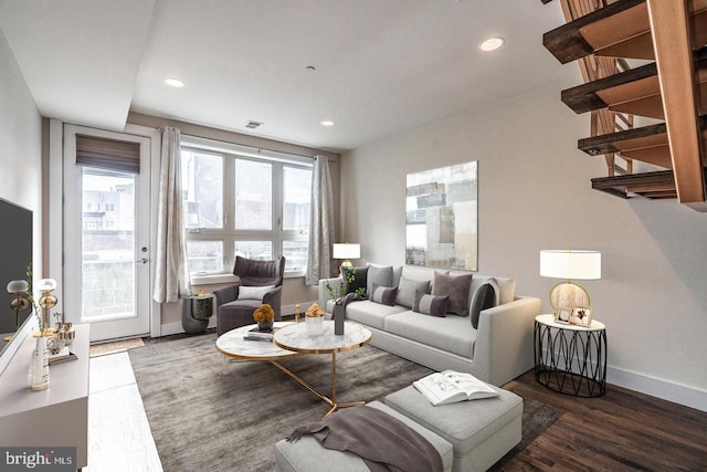 living room with plenty of natural light and dark wood-type flooring