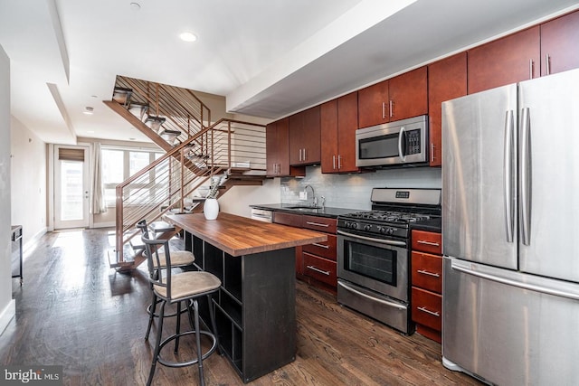 1538 Ogden St Unit 2A, Philadelphia, PA 19130 - kitchen featuring dark wood-style floors, backsplash, appliances with stainless steel finishes, butcher block counters, and recessed lighting