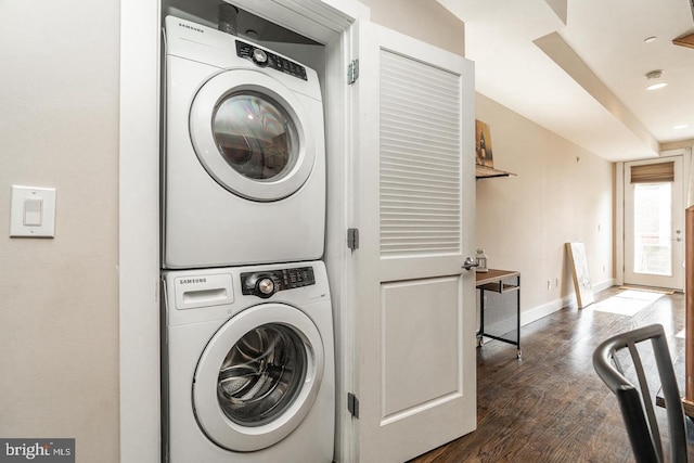 laundry room with dark wood-type flooring and stacked washing maching and dryer