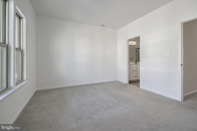 empty room with a wealth of natural light and light colored carpet