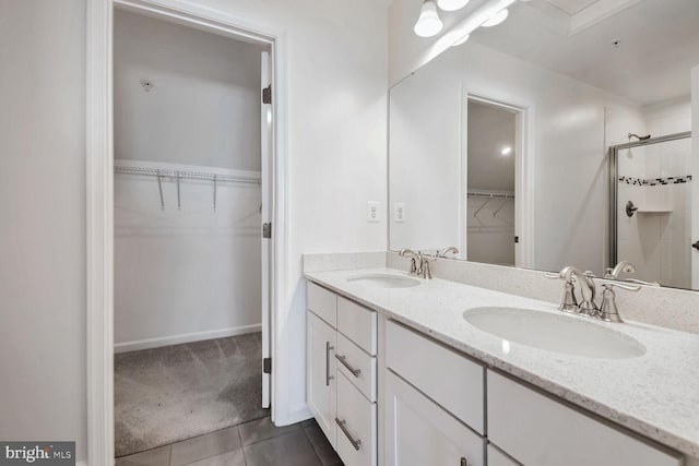 bathroom featuring tile patterned floors, vanity, and a shower with shower door