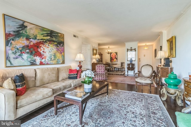 living room featuring ornamental molding, an inviting chandelier, and dark hardwood / wood-style floors