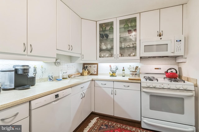 kitchen featuring tasteful backsplash, white appliances, and white cabinets