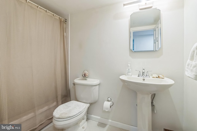 bathroom featuring curtained shower and toilet