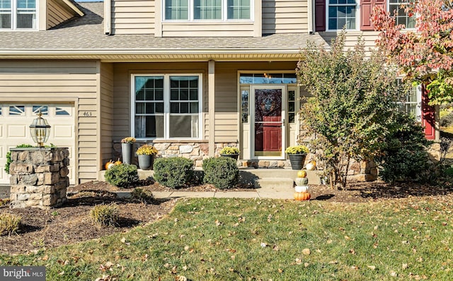 entrance to property featuring a garage and a yard