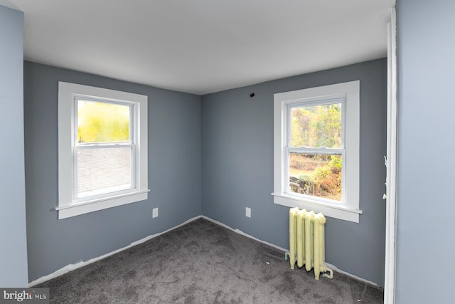 carpeted spare room featuring radiator