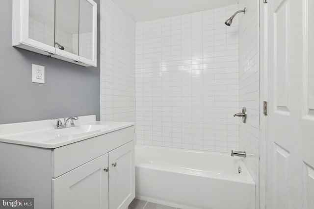 bathroom featuring tiled shower / bath and vanity