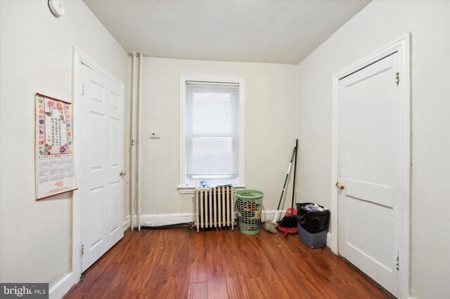 misc room featuring radiator heating unit and dark wood-type flooring