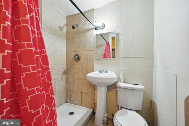 bathroom with a shower with curtain, toilet, and sink