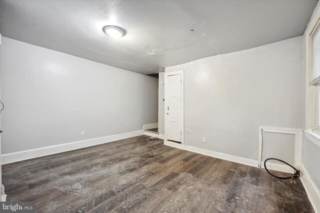 empty room with dark hardwood / wood-style flooring