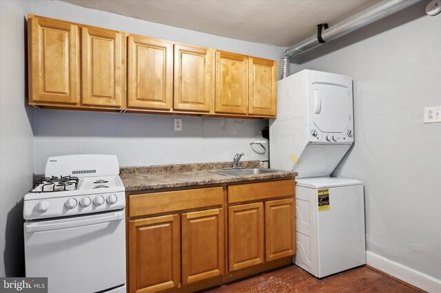 kitchen with dark hardwood / wood-style floors, stacked washer / dryer, white gas range oven, and sink