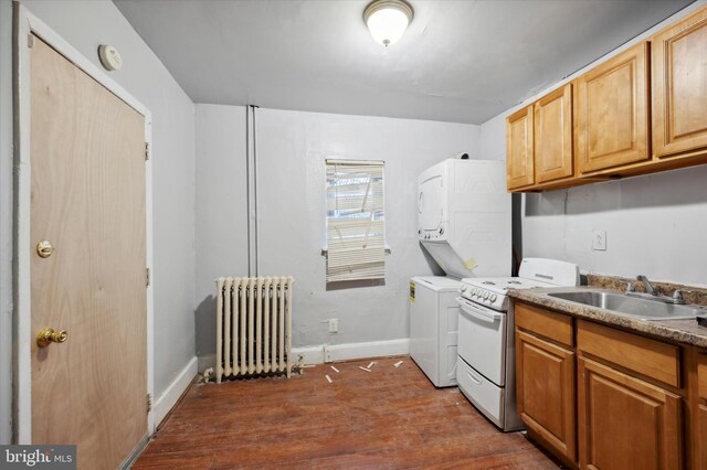 clothes washing area featuring dark hardwood / wood-style flooring, radiator heating unit, sink, and stacked washer / dryer