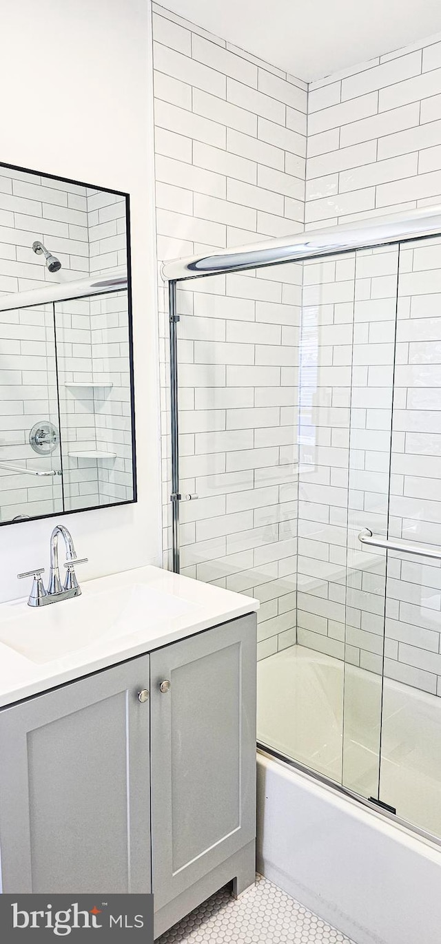 bathroom featuring vanity, bath / shower combo with glass door, and tile patterned floors