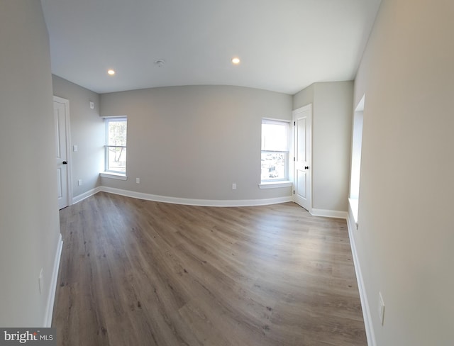 empty room featuring wood-type flooring and a healthy amount of sunlight